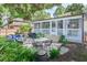 Backyard featuring a screened porch, stone patio with dining set, and blue cushioned outdoor sofa at 938 Sea Gull Dr, Mount Pleasant, SC 29464