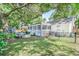 Expansive backyard with a screened porch, stone patio, and lush green lawn surrounded by mature trees at 938 Sea Gull Dr, Mount Pleasant, SC 29464