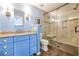 Updated bathroom features a granite-topped vanity, blue-painted cabinets, and tiled walk-in shower with glass door at 938 Sea Gull Dr, Mount Pleasant, SC 29464