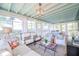 Inviting sunroom with ample seating, a light blue-painted ceiling, and windows overlooking a lush backyard at 938 Sea Gull Dr, Mount Pleasant, SC 29464
