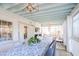 Beautiful sunroom with blue-painted ceiling, a dining table, white wicker chairs, and lots of natural light at 938 Sea Gull Dr, Mount Pleasant, SC 29464