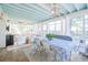 Bright sunroom features a dining table with a patterned tablecloth, white seating, and ample natural light at 938 Sea Gull Dr, Mount Pleasant, SC 29464