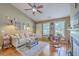 Bright living room featuring a comfortable sofa, ceiling fan, and natural light from multiple windows at 1004 Providence Way, Summerville, SC 29483
