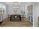 Elegant dining room with a modern chandelier, wainscoting, and large windows at 101 Guernsey Ln, Summerville, SC 29483