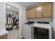 Laundry room with modern washer and dryer, and cabinets for storage, leading to a walk-in closet at 101 Guernsey Ln, Summerville, SC 29483