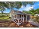 This backyard deck features wooden steps leading from a screened-in porch, a fenced-in backyard, and trees overhead for shade at 1034 Steelechase Ln, Hanahan, SC 29410