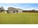 Large grassy backyard with neighboring homes and visible powerlines on a sunny day at 1035 Forrest Creek Dr, Summerville, SC 29483