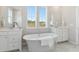 Luxurious bathroom featuring a freestanding tub, marble floors, double vanities, and bright natural light at 1051 Scotch Bonnet Way, Summerville, SC 29485