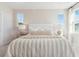 Cozy main bedroom featuring plush carpet, bright windows, stylish lamps, and a decorative tufted headboard at 1051 Scotch Bonnet Way, Summerville, SC 29485