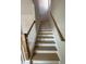 Stairway with wood treads, white risers, and a natural wood handrail leading upstairs at 1051 Scotch Bonnet Way, Summerville, SC 29485