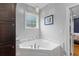 Bathroom featuring a soaking tub with tile surround and a view through the window at 110 Huntington Ct, Walterboro, SC 29488