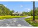 Inviting ranch-style home with a long driveway and lush green lawn surrounded by mature trees at 110 Huntington Ct, Walterboro, SC 29488