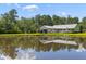Peaceful backyard view of the home with a pond, covered parking, and natural surroundings at 110 Huntington Ct, Walterboro, SC 29488