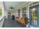 View of the covered porch with a fan, firewood, a grill, and doors at 110 Huntington Ct, Walterboro, SC 29488