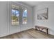 Bright entryway features natural light from glass doors, wood-look floors, and a charming wooden bench at 110 True Blue Lp, Summerville, SC 29486