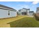 Backyard with green lawn and view of the rear of the house and detached garage at 113 Jackson Pond Ct, Summerville, SC 29486