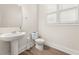 Well-lit half bath with pedestal sink, toilet, wood floors, and shuttered window at 113 Jackson Pond Ct, Summerville, SC 29486