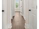 Hallway with wood floors, white doors, and a window letting in natural light at 113 Jackson Pond Ct, Summerville, SC 29486