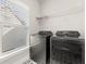 Laundry room with a window, shelving, and modern front-loading washer and dryer at 113 Jackson Pond Ct, Summerville, SC 29486