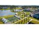 An aerial view shows lake, clubhouse, pool, walking paths, bocce ball and residential homes surrounded by mature trees at 114 Magnolia House Dr, Summerville, SC 29486