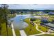 Aerial view of a lake community featuring a boat launch, tennis courts, swimming pool and clubhouse with manicured lawns at 114 Magnolia House Dr, Summerville, SC 29486