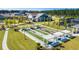 An aerial shot shows manicured bocce ball courts with pergolas and a lush lawn lined with walking paths and sidewalks at 114 Magnolia House Dr, Summerville, SC 29486
