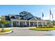 Charming clubhouse exterior with a welcoming entrance, manicured landscaping, and American flags at 114 Magnolia House Dr, Summerville, SC 29486