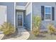 Close up of a front door with manicured landscaping, bushes with flowers, and dark shutters at 124 Pontoria Dr, Knightsville, SC 29483