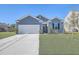 Charming single-Gathering home featuring a two-car garage, well-maintained lawn, and a classic blue exterior at 124 Pontoria Dr, Knightsville, SC 29483