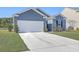 This property boasts a two-car garage, concrete driveway, lush green lawn, and mature landscaping at 124 Pontoria Dr, Knightsville, SC 29483