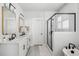 A modern bathroom featuring dual sinks, gold framed mirrors, and a glass-enclosed shower at 1244 Crooked Oak Rd, Charleston, SC 29492