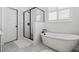 Bright bathroom with a freestanding tub, tiled shower, and window with white shutters at 1244 Crooked Oak Rd, Charleston, SC 29492