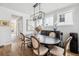 A cozy dining area featuring a modern chandelier, a dark wood table, and hardwood floors at 1244 Crooked Oak Rd, Charleston, SC 29492