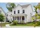 Inviting two-story home with a classic white exterior, front porch, and lush landscaping at 1244 Crooked Oak Rd, Charleston, SC 29492