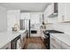 A modern kitchen featuring white cabinets, stainless steel appliances, and hardwood floors at 1244 Crooked Oak Rd, Charleston, SC 29492