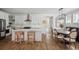 A stylish kitchen featuring white cabinets, a herringbone backsplash, and an island with rattan stools at 1244 Crooked Oak Rd, Charleston, SC 29492