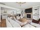 Open-concept living room with a fireplace, built-in shelving, and seamless flow into the kitchen and dining area at 1244 Crooked Oak Rd, Charleston, SC 29492