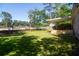 A brick house features a wooden deck and a spacious grassy backyard fenced at the back at 1261 Hampshire Rd, Charleston, SC 29412