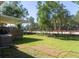 Spacious backyard featuring a lush lawn, mature trees, and a covered patio area at 1261 Hampshire Rd, Charleston, SC 29412