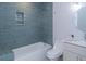 Beautiful bathroom with tiled tub, a modern vanity with a round mirror, and updated fixtures at 1261 Hampshire Rd, Charleston, SC 29412