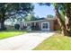 Brick home with a well-manicured lawn, an American flag, and a paved driveway at 1261 Hampshire Rd, Charleston, SC 29412
