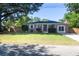 Classic brick home featuring a lush green lawn, mature trees, and a paved driveway at 1261 Hampshire Rd, Charleston, SC 29412