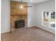 Living area showcases new flooring, a brick fireplace, and natural light from the nearby window at 1261 Hampshire Rd, Charleston, SC 29412