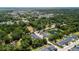 Aerial view showcases a neighborhood, nearby lake, and mature trees against a distant coastline at 1300 Enfield Ln, Mount Pleasant, SC 29466