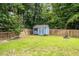 Well-kept backyard shed framed by a neat lawn, wooden fence, and green foliage at 1300 Enfield Ln, Mount Pleasant, SC 29466