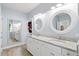 Bathroom with double vanity, granite counters, round mirrors and wood-look tile floors at 1300 Enfield Ln, Mount Pleasant, SC 29466