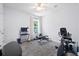 A compact exercise room with gray carpeting, stationary bike, weight bench, and a desk with a computer at 1300 Enfield Ln, Mount Pleasant, SC 29466