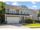 Charming two-story home with a well-manicured lawn, two car garage, and inviting front porch with beautiful landscaping at 1300 Enfield Ln, Mount Pleasant, SC 29466