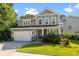 Charming two-story home with a well-manicured lawn, two car garage, and inviting front porch with beautiful landscaping at 1300 Enfield Ln, Mount Pleasant, SC 29466