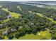 Stunning aerial view of houses nestled among lush trees alongside a golf course and waterfront scenery at 132 Turnberry Dr, Johns Island, SC 29455